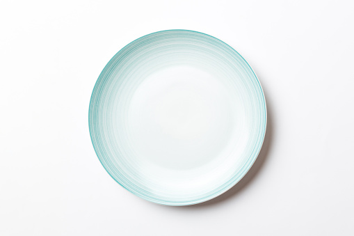Top view of isolated of colored background empty round blue plate for food. Empty dish with space for your design.
