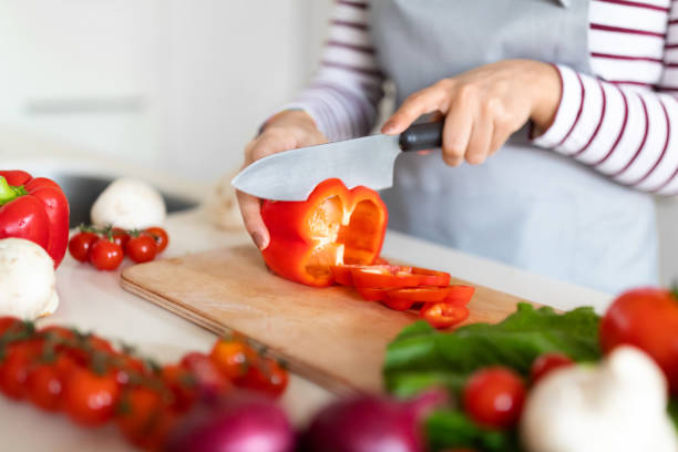 istock Female hands cutting fresh vegetables on chopping board 1473500736