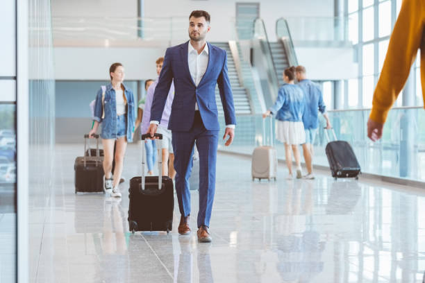 istock Passengers walking with luggage at airport 1473501067