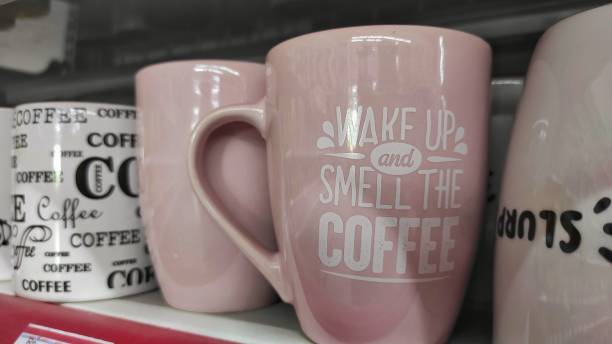 Pink and white ceramic mug with quotes on it displayed on storefront of supermarket