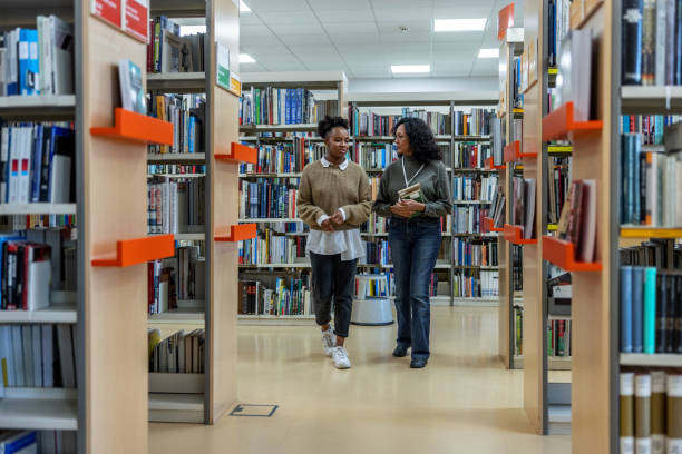 istock Latin-American Librarian Helping An African-American Student 1473503538