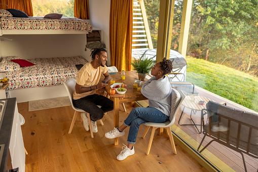 Diverse young adult Hispanic couple enjoying a colorful breakfast at weekend getaway. Getting away from everything and spending some quality time together.