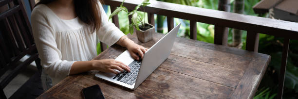istock Woman using laptop on table at a hotel, summer vacation. 1473503794