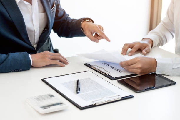 istock Insurance agent discussing with customer about insurance policy documents. 1473505444