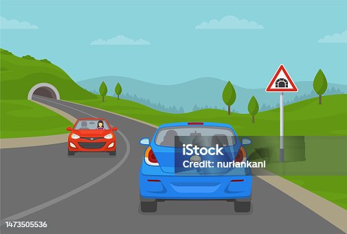 istock Blue sedan car driving into mountain road tunnel. Tunnel ahead warning road or traffic sign. 1473505536