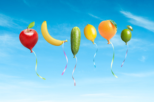 Fruits and vegetables balloons concept on blue sky. This file is cleaned and retouched.