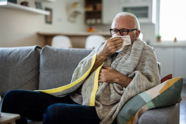 istock Sick and depressed older man is having high temperature and using handkerchiefs in the bed, trying to override the sickness. Senior man is fighting with the sickness and feeling desperate. 1473505769