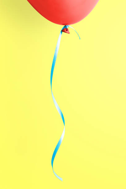 istock Red balloon on yellow background 1473505935
