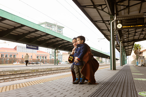 Mother and son waiting on a train station. Pordenone, Italy, Europe