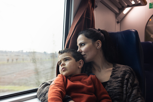Mother and son traveling by the train. Pordenone and Venice, Italy