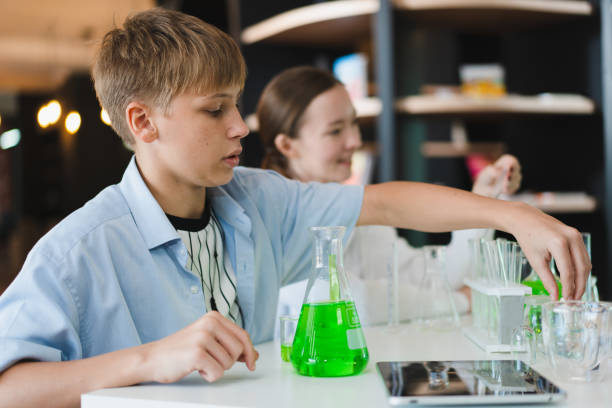 кавказские дети и кавказские учителя изучают науку с помощью химической пробирки - laboratory test tube student scientist стоковые фото и изображения