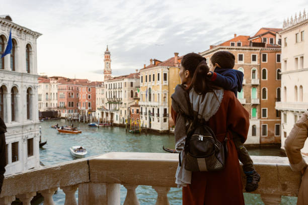 Mother and son sightsee Venice from Grand Canal bridge stock photo