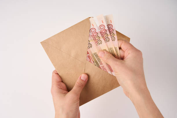 istock Hands holding envelope with Russian Ruble money 1473509931