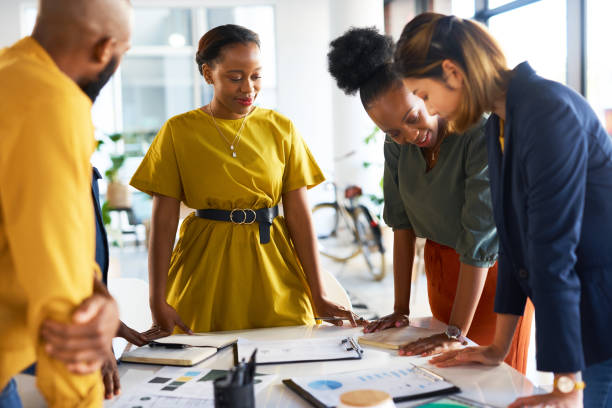 istock Business people, creative teamwork and planning paperwork in agency for innovation, strategy and ideas. Group of designers meeting with documents, brainstorming information and data analysis graphs 1473510270