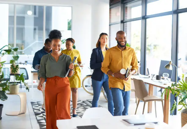 Business people, teamwork and walking in office for meeting, planning and motivation in happy agency. Diversity group of employees walk in company for collaboration, workshop management and support