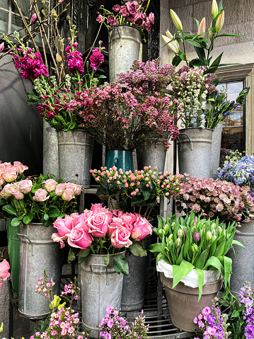 Bright flower stalls somewhere in London. Roses, tulips, and all other vibrant flowers placed in buckets and bouquets. These are the beauty for the eye.