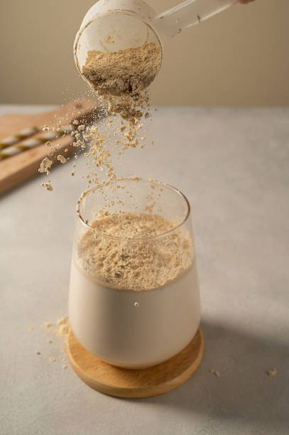 istock Pouring protein powder in glass with milkshake. 1473512317