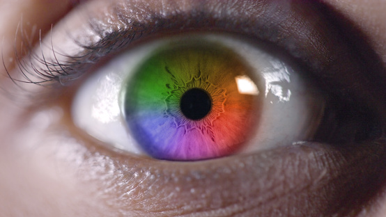 Pupils, vision and closeup of a rainbow eye wide open with beautiful long eyelashes and eye care. Eyesight, optical wellness and macro zoom of a eyeball with a colorful iris with contact lenses.