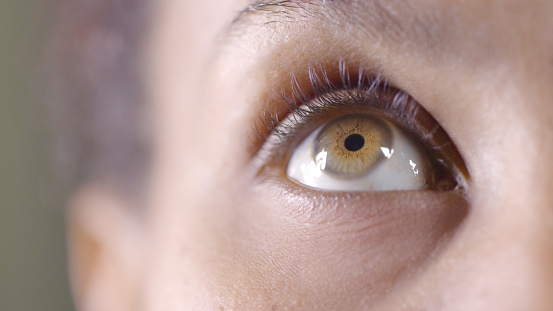 Macro shot of a human female eye, iris, cropped on black background, usable as creative background