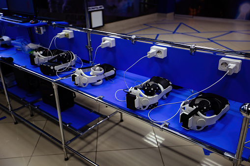 Many virtual reality VR sets are charging in VR room.