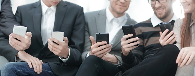 close up.the business team uses their smartphones sitting in the lobby of the office