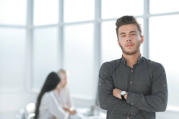 istock young business man standing in his office 1473519097