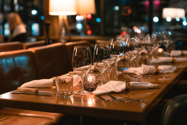 istock Restaurant long dining table setting with silverware and wineglass for catering 1473519260