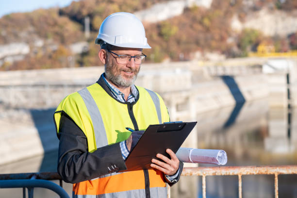 istock A bearded and bespectacled engineer in front of a dam retaining wall. 1473520118