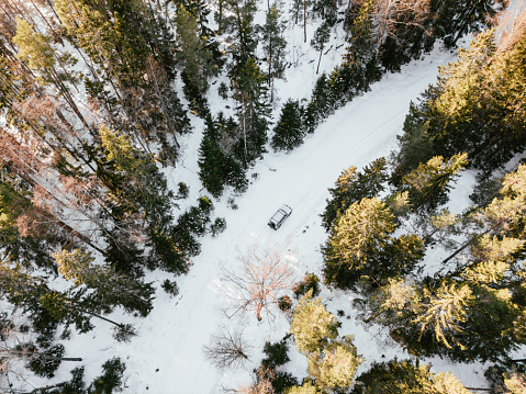 Drone image showcases the beauty of winter driving, with the car effortlessly gliding through the snowy terrain.