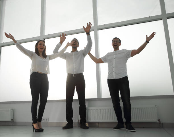 istock happy business team standing near office window. 1473520794