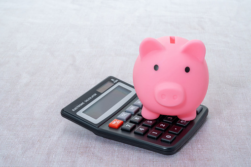 Piggy bank resting on a calculator