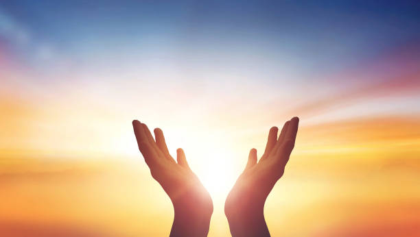 istock Human hands open palm up worship at sunset Sky background 1473524634