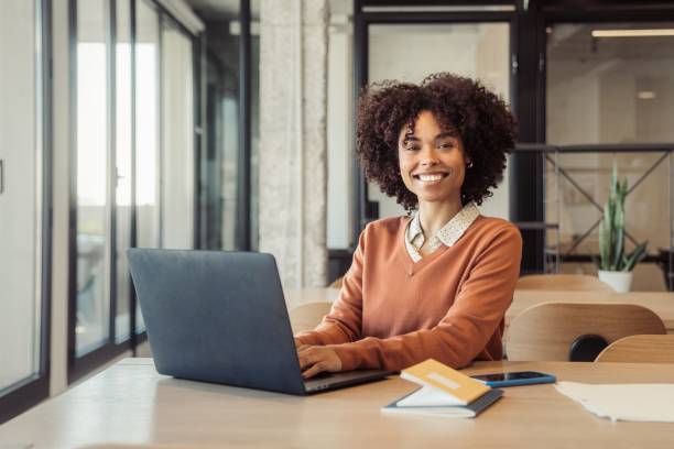 istock Young woman in office smiling while working 1473525639