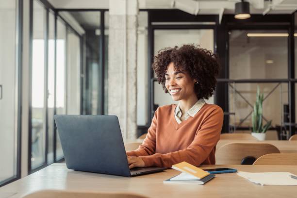 istock Young woman in office smiling while working 1473525644