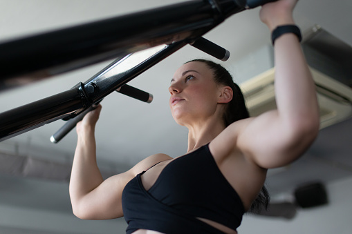 Strong woman pulling up portrait in gym