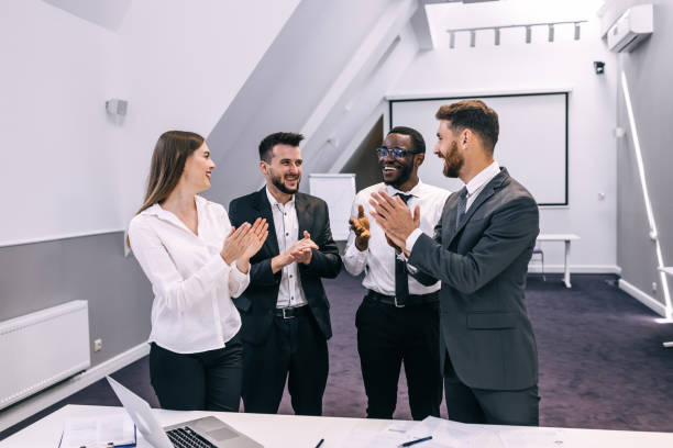 istock Happy business team clapping hands at workplace celebrating new 1473530114