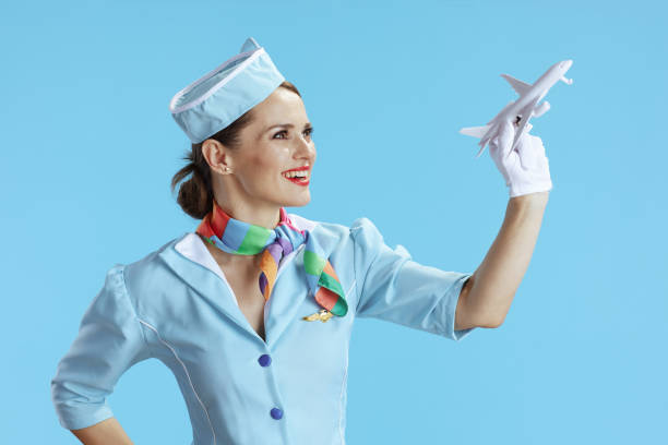 istock smiling modern female air hostess on blue 1473532960