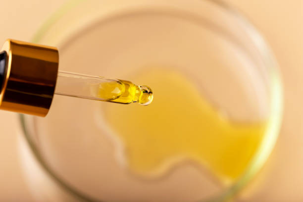 istock Dropper with yellow liquid over the petri dish 1473534413