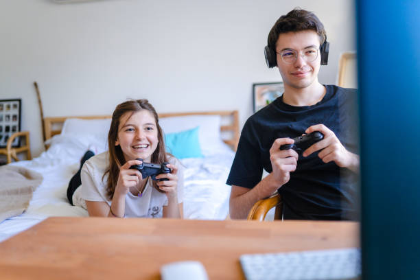 istock Siblings playing video game together at home 1473535732