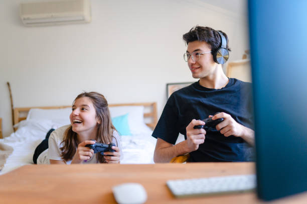 istock Siblings playing video game together at home 1473535746