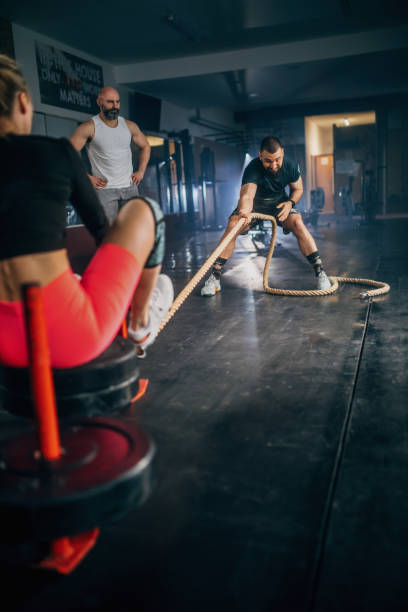 istock male athlete pushing and pulling  the sled in the gym 1473539651