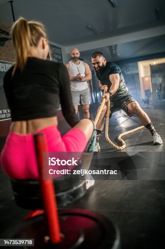 istock male athlete pushing and pulling  the sled in the gym 1473539718