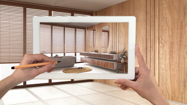 istock Augmented reality concept. Hand holding tablet with AR application used to simulate furniture and design products in empty wooden interior with marble floor, minimalist bathroom 1473540854