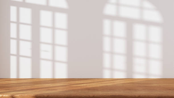 istock Wooden table with white stucco wall background with window light beam and shadow. Product presentation mock up. Empty interior design concept 1473540933