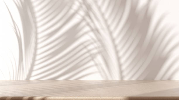 istock Beige marble table with white stucco wall background with light beam and palm leaves shadow. Product presentation mock up. Empty interior design concept 1473540934