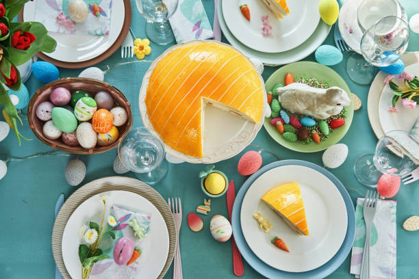 istock Colorful Decorated Easter Table with Easter Eggs, Flowers and Carrot Easter Cake 1473541324