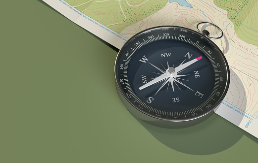 Navigational compass positioned on the edge of a map, isolated on a green background - 3D render.