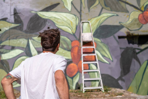 istock A graffiti artist paints graffiti on a large retaining wall. 1473542583