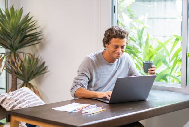 istock A white businessman work from home while drinking a cup of cofee. 1473543542