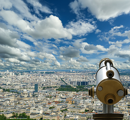 Telescope viewer and city skyline at daytime (against the background of very beautiful clouds). Paris, France.